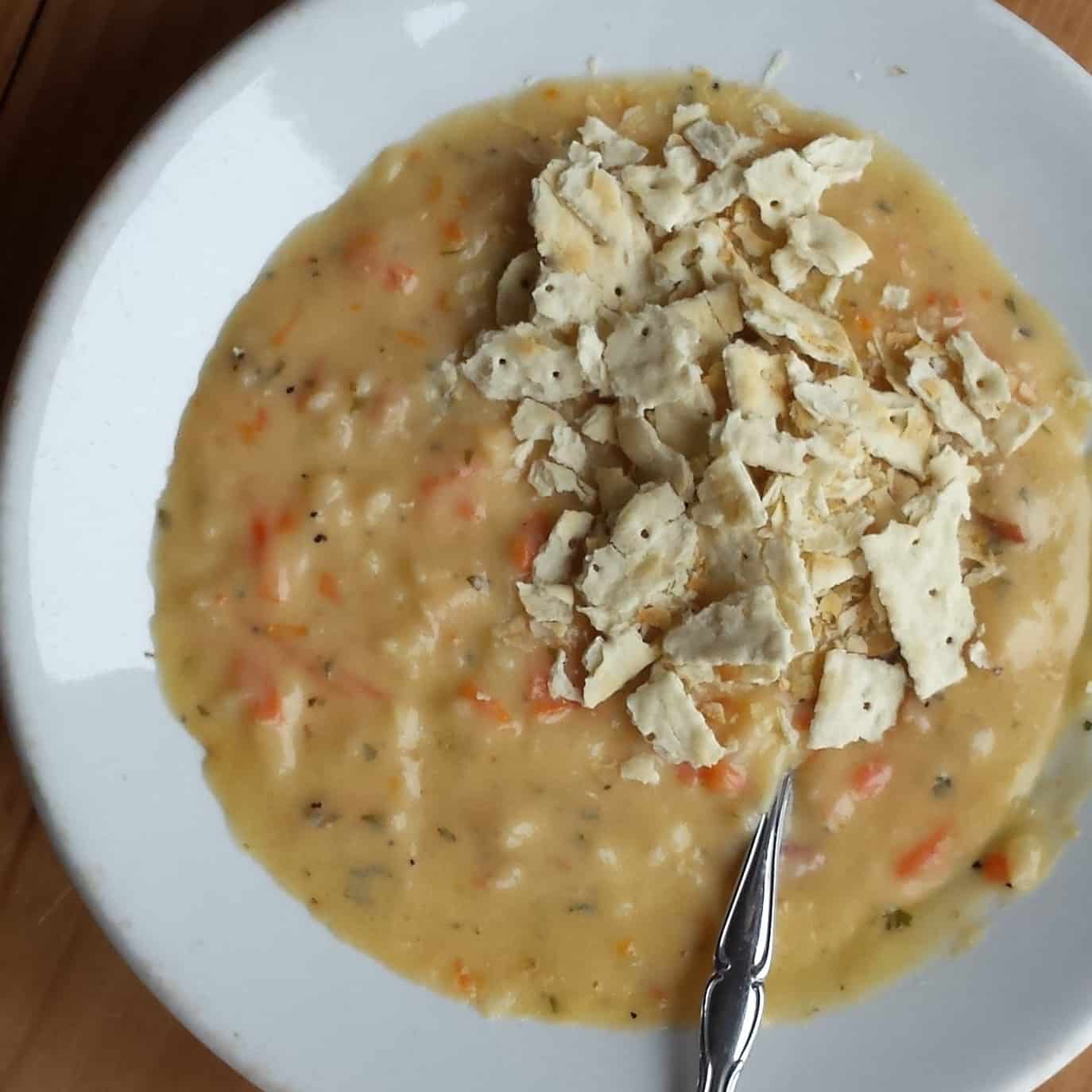 Overhead image of Canadian Cheese Soup in white bowl with saltine crackers.