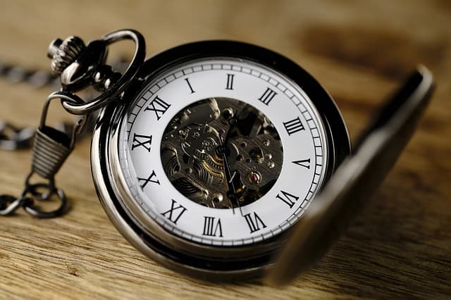 open pocket watch on wood table