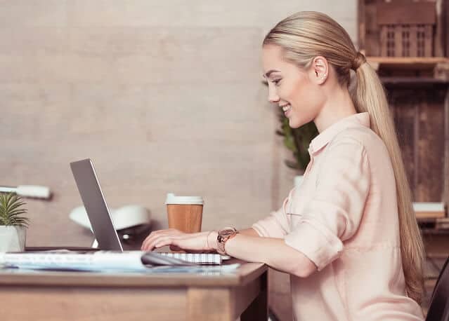 young woman working diligently on laptop