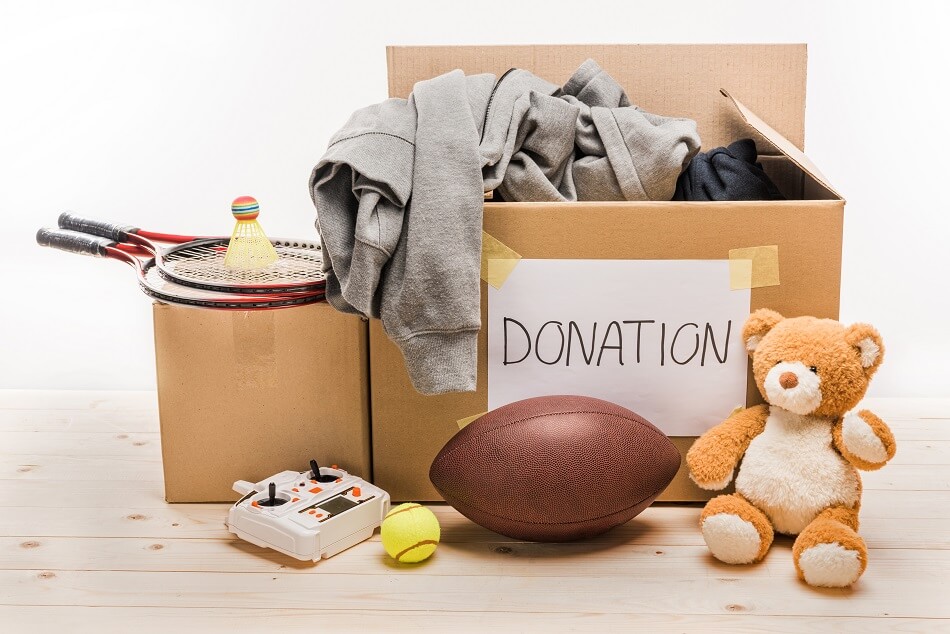 boxes of toys and sports equipment ready to donate after decluttering