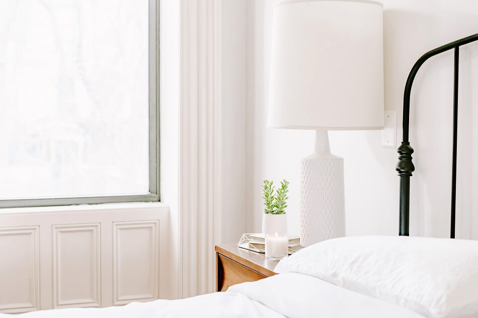 clutter-free white bedroom with bed and lamp near window