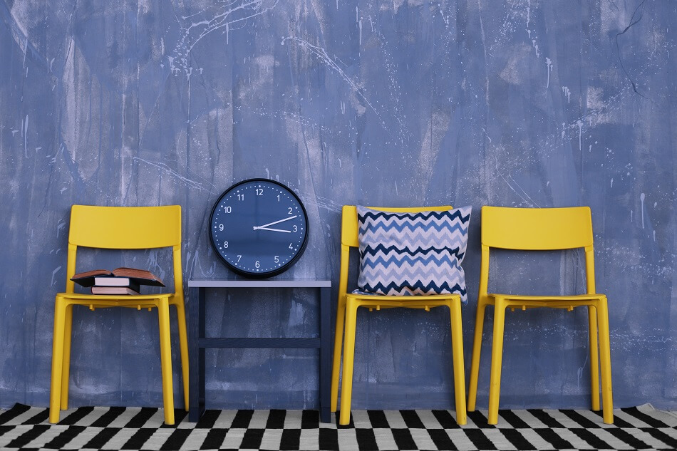 yellow chairs blue chevron pillow books and clock against blue wall