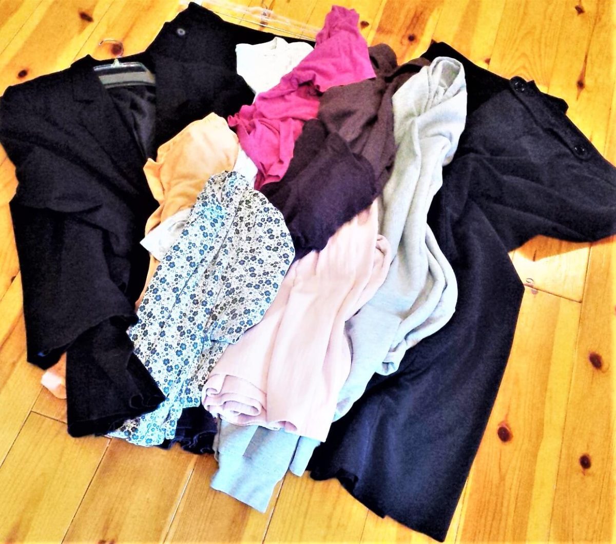 pile of decluttered clothing on wood floor