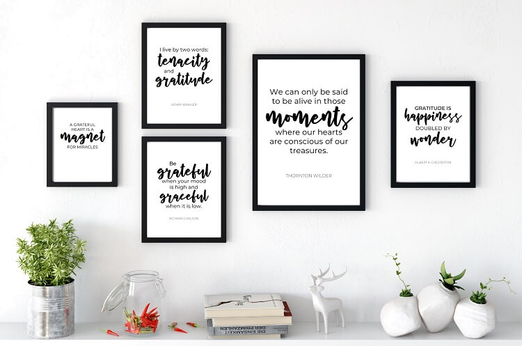 free printable black and white gratitude quotes in black frames on white wall above shelf with home decor items