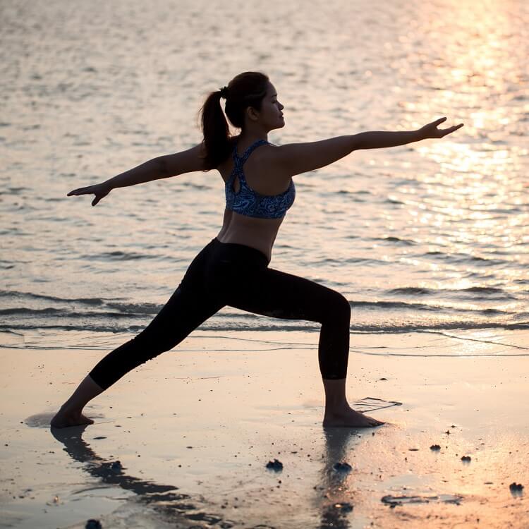 woman conquering laziness and exercising on beach at sunrise