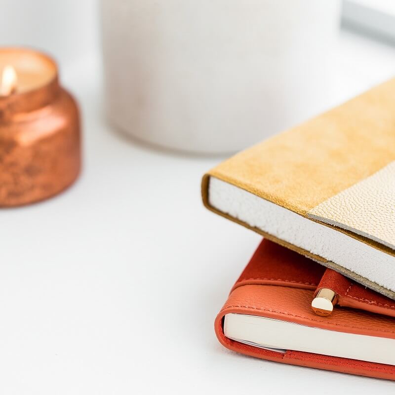 two notebooks ready to use for december journal writing against blurry background