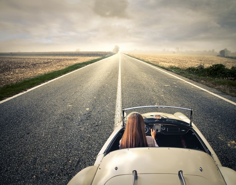 woman with long hair in car ready to begin a journey down a long road with guidance from her word of the year