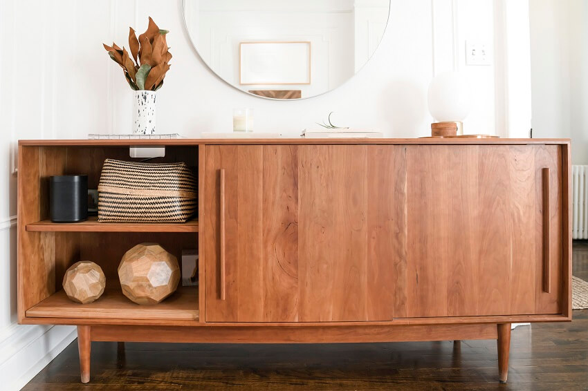 wood credenza against white wall with neutral color decor