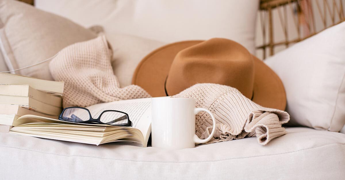 comfortable white couch with cowboy hat coffee mug glasses cozy blanket glasses and books