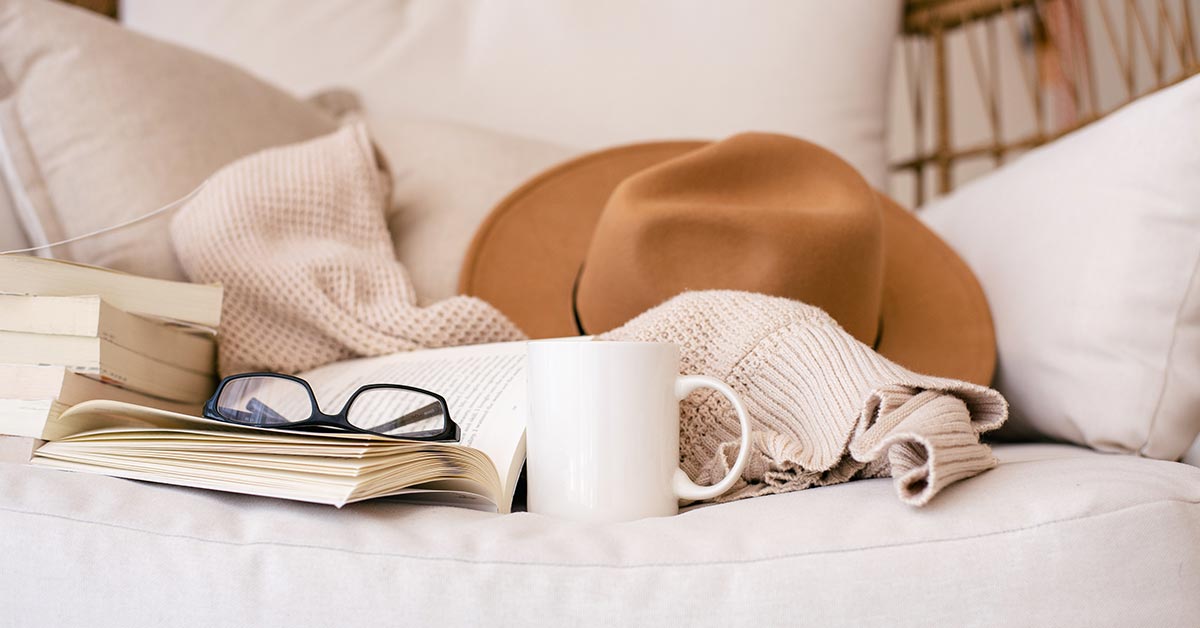 comfortable white couch with cowboy hat coffee mug glasses cozy blanket glasses and books