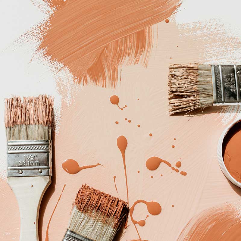 paint brushes and paint swishes and drips in warm orange autumn tones