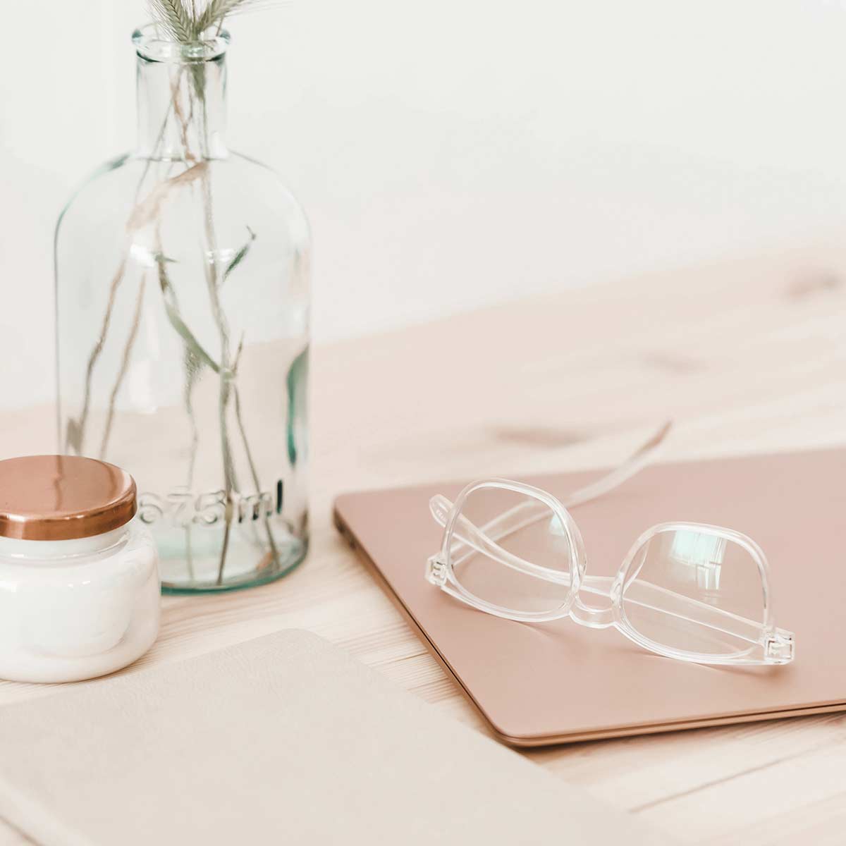 glasses, laptop, journal, glass jars on wood table