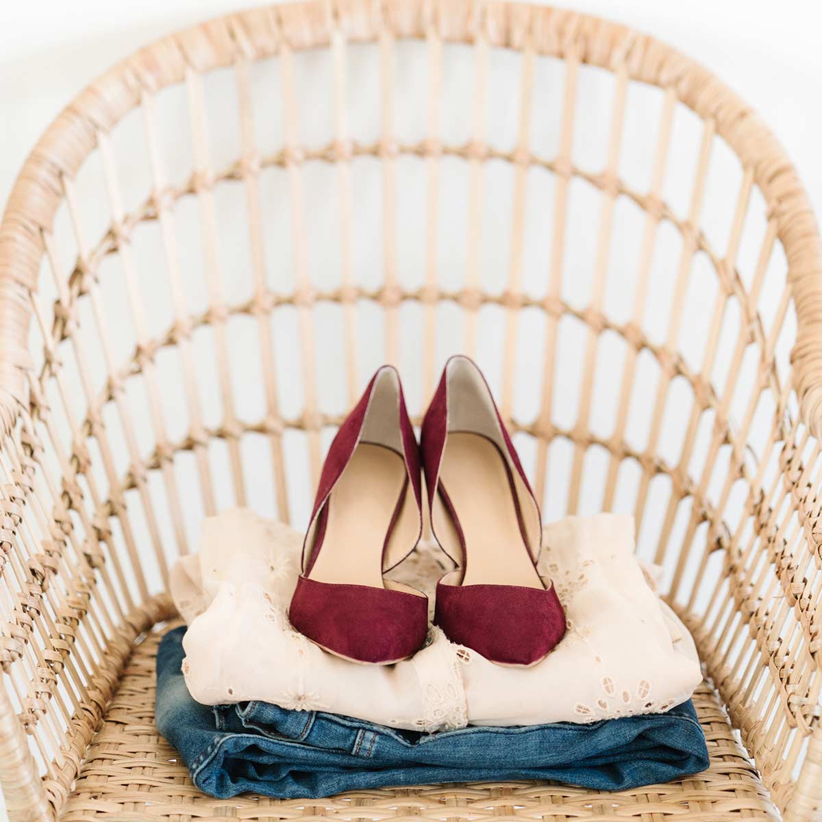 woman's jeans, shirt, red shoes - folded, placed on wicker chair, and ready for the day