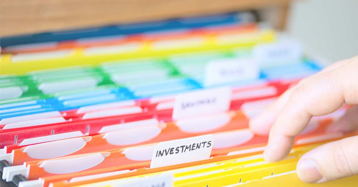 Adult hand flipping through colorful organized household files.