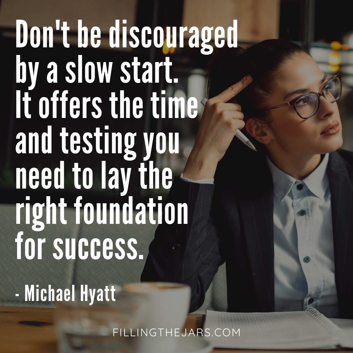 Michael Hyatt slow start quote in white text over background of young woman wearing glasses and business attire working at a cafe table.