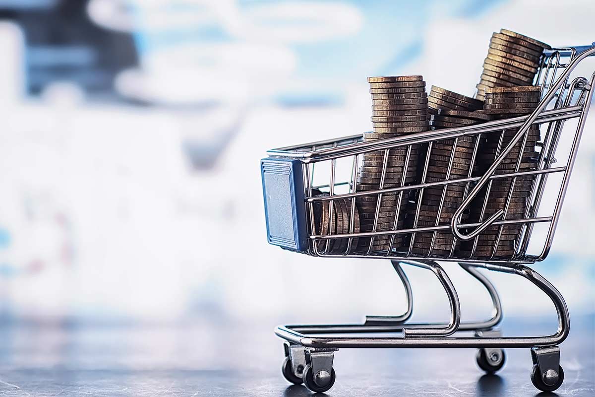 Small cart with coins representing saving money by grocery shopping once a month.