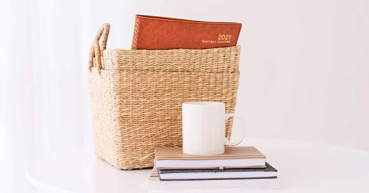 Feature image for quotes about being organized with baskets and planners on white table with white coffee mug.