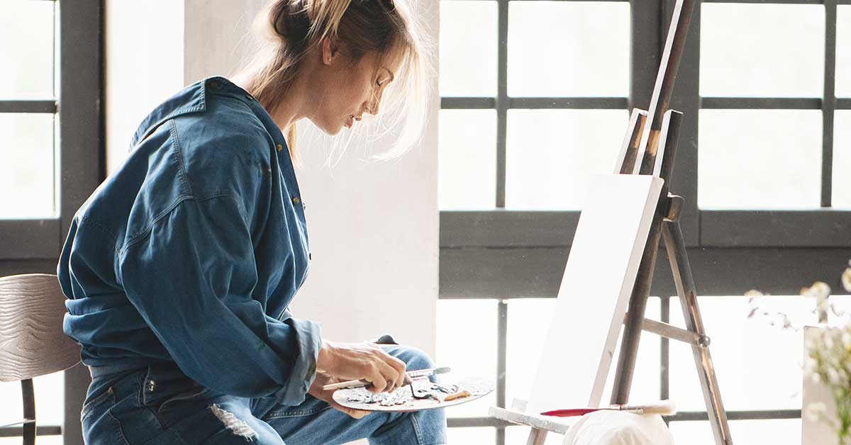 Woman preparing to paint during the day in a bright room.