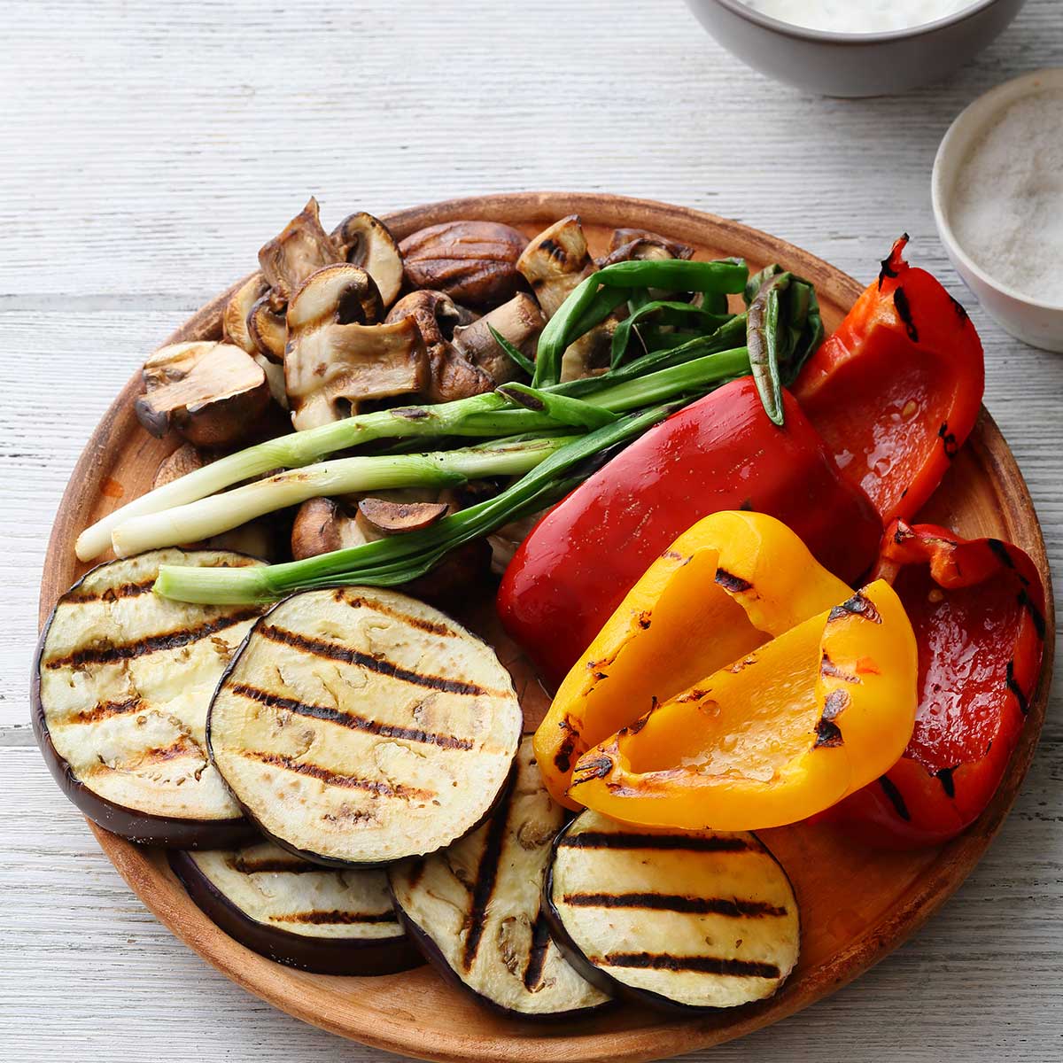 Summer grilled vegetables on wooden plate.