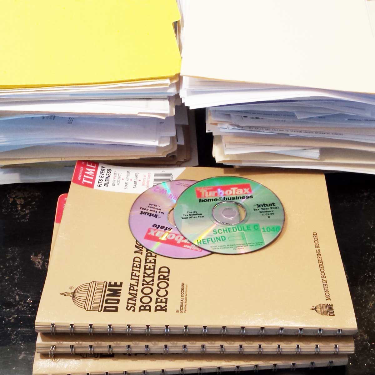 Piles of papers and files from decluttering a messy office.