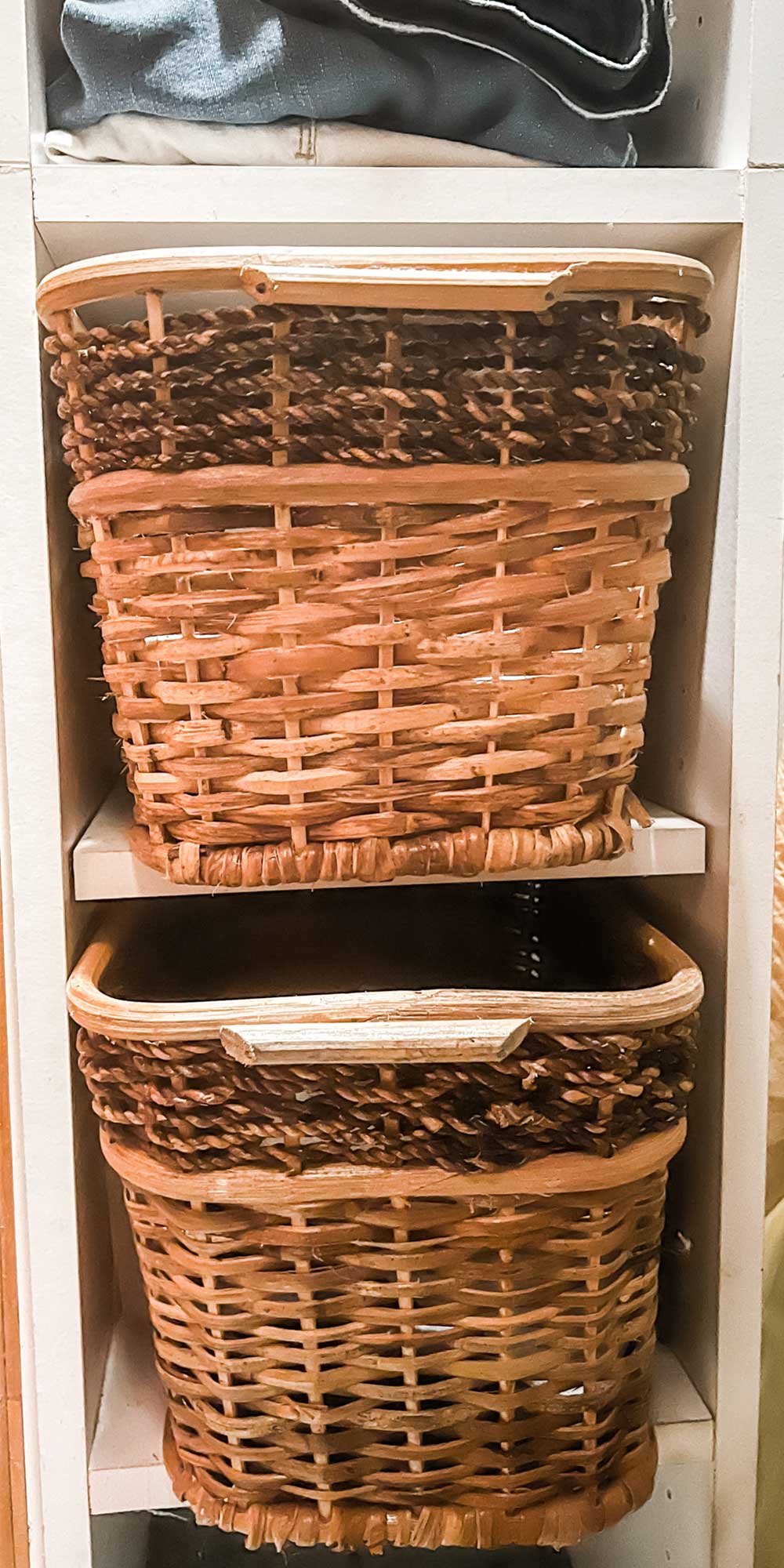 Closet organization created with stackable shelves and wicker baskets.