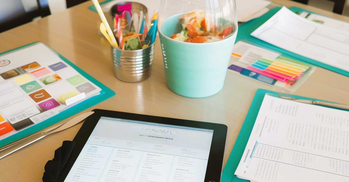 Monthly meal planning supplies on a wood table.